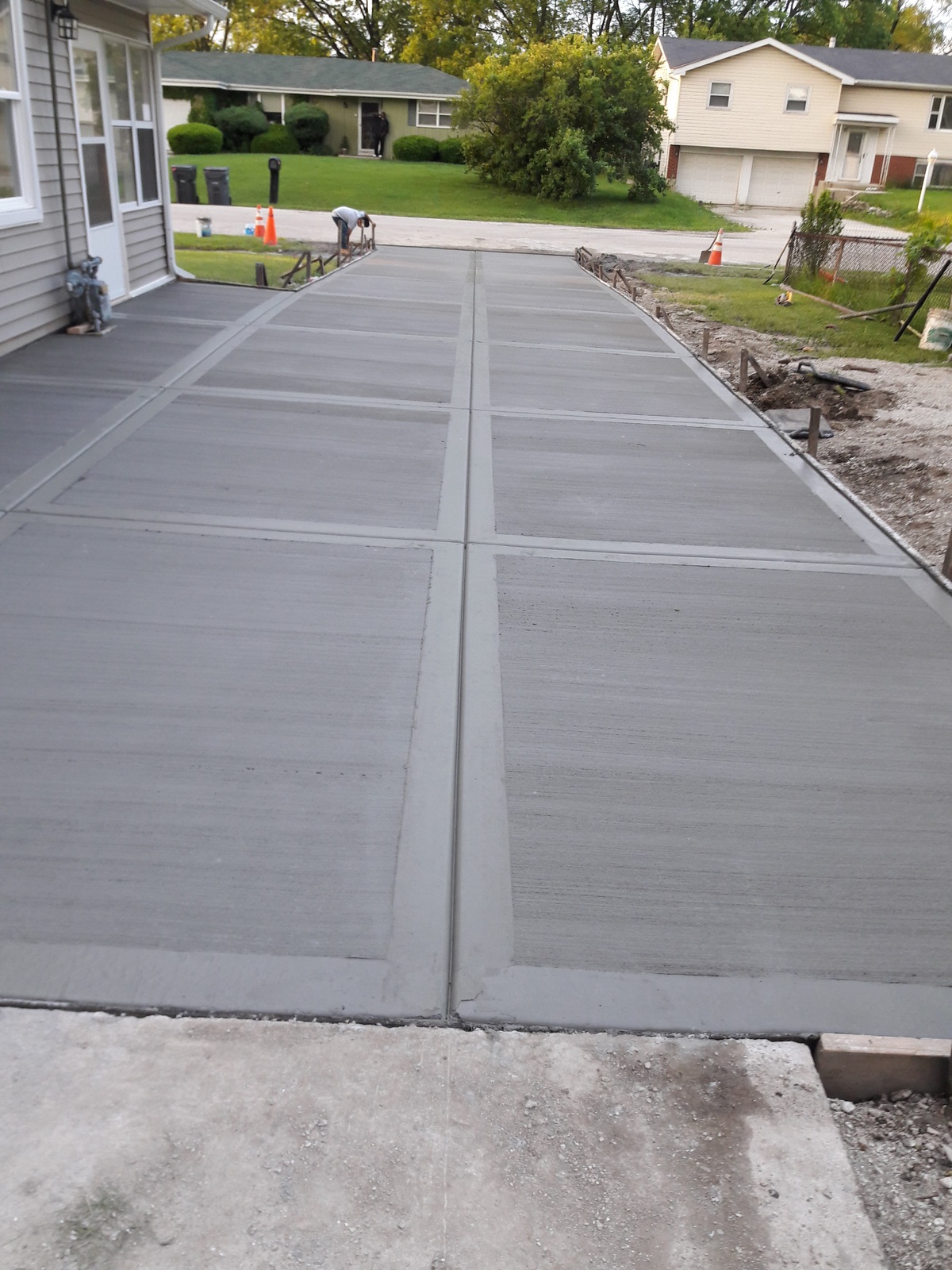 Curved concrete walkway beside a home